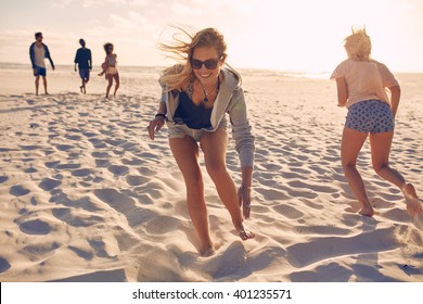 Young Women Running Race On The Beach. Group Of Young People Playing Games On Sandy Beach On A Summer Day. Having Fun On The Beach.