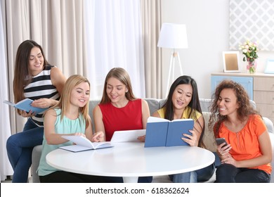 Young Women Sitting At Table In Book Club