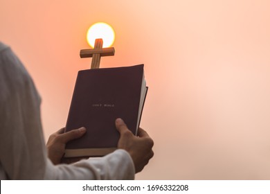 Young women study the scriptures. The sunrise background or whether the sunset The educational concept of Christian Tipitaka that is open and praying to God.