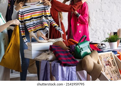 Young women at swap home party - clothes, shoes, bags, jewellery exchange between friends. Zero waste shopping, eco friendly concept, sustainable lifestyle. College life.  - Shutterstock ID 2141959795
