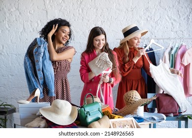 Young Women At Swap Party. Trying On Casual Clothes, Shoes, Hats, Bags, Jewellery. Idea Of Exchange Your Old Wardrobe For New. Eco Friendly Cloth Concept. Zero Waste Shopping, Reduce And Reuse, Donate