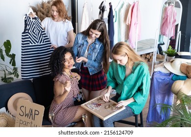 Young Women At Swap Party. Trying On Casual Clothes, Shoes, Hats, Bags, Jewellery. Idea Of Exchange Your Old Wardrobe For New. Eco Friendly Cloth Concept. Zero Waste Shopping, Reduce And Reuse