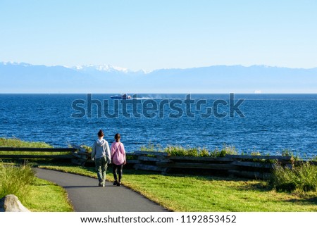 Young women walking along the coastline, Canada