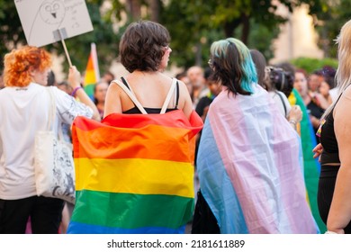 Young Women Walking At Pride Parade With Rainbow Flags As Symbol Of Pride Month. Queer Community March In The Street With Crowds. Pride And Trans Flags: VALENCIA, SPAIN - JUNE 25 2022