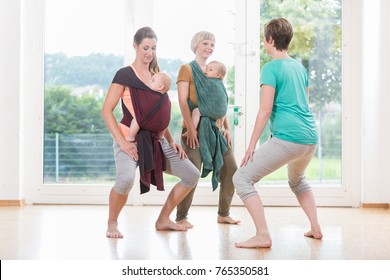 Young Women Wearing Babies For Mother-child Bonding And Doing Pelvis Floor Exercises