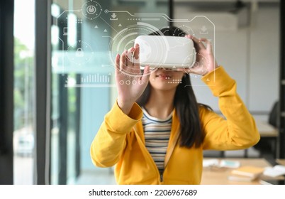 Young women wearing virtual reality headsets keep track of technology and business advancements, through hologram screens, technology ideas and investments. - Powered by Shutterstock