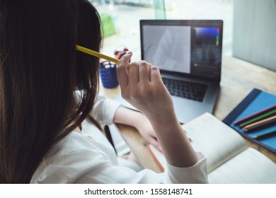 Young Women Working With Color Pencil And Notebook And Computer Laptop For Using Design Or Creative  To Drawing Draw Clothes Design. Freelance At Work Concept.