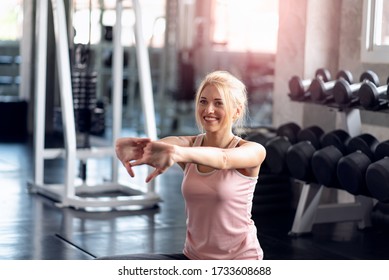 Young women workout in the gym, doing exercise stretching her arms, Healthcare lifestyle concept