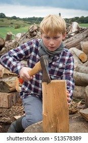 Young woodcutter boy chopping a piece of wood with an axe