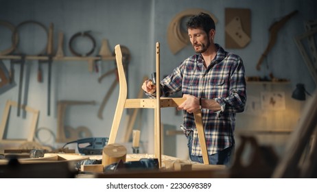 Young Woodworker Checking the Layout Manual of a Stylish Handmade Wooden Chair. Talented Furniture Designer Working in a Workshop in a Creative Loft Space with Tools and Equipment. - Powered by Shutterstock