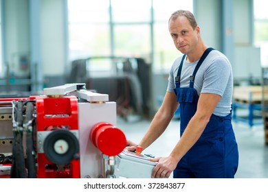 young worker in factory using machine