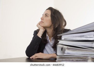 Young Worker In His Office With Many Folders Thinking About Holidays