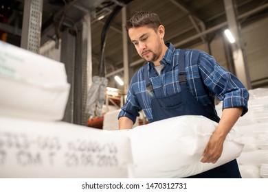 Young Worker Of Polymer Production Factory Loading Sacks With Plastic Granules