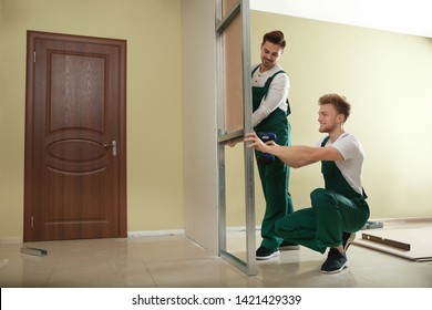 Young Workers Installing Drywall Indoors. Home Repair Service