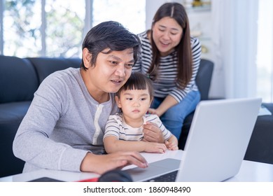 Young Working Father Work From Home While Babysitting His Playful Daughter At Home. Working Father And Daughter Playing Beside.