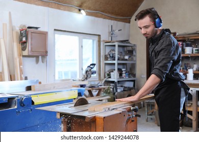 Young working man using circular saw at carpentry shop - Powered by Shutterstock