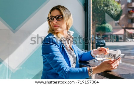 Young woman stiring coffee looking back