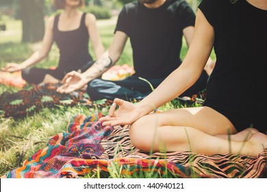 Young Yoga Practitioners In Group Doing Yoga On Nature.