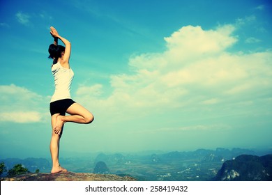 young yoga woman mountain peak