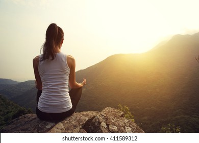 young yoga woman at spring mountain peak