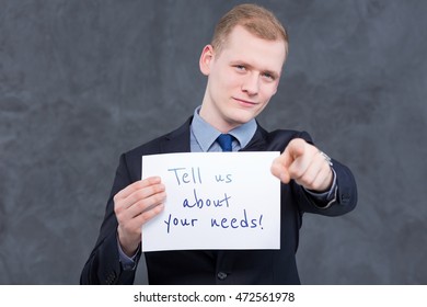 Young,elegan Man In Suit, Pointing Something In Front Of Him And Holding A Piece Of Paper With Writing