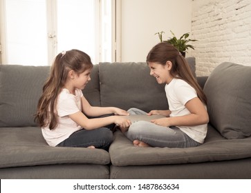 Younger And Older Girls Fighting For Laptop Arguing Over Playing On The Internet. Lifestyle Portrait Of Sisters Not Sharing Computer In Relationship Between Siblings And Technology Addiction Concept.