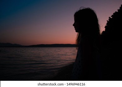 youngh girl silhuette after sunset by the sea