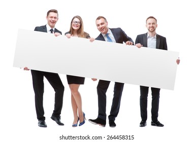 Your Advertisement In Good Hands. Group Of Handsome Young Business People Holding Big Blank With Copy Space. Isolated On White.