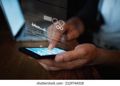 Your browsing history leaves a perfect trail for hackers. Closeup shot of an unidentifiable hacker using a cellphone in the dark.