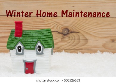 Your House In The Winter Season, A Green And Red House On Snow And A Weathered Wood Background With Text Winter Home Maintenance