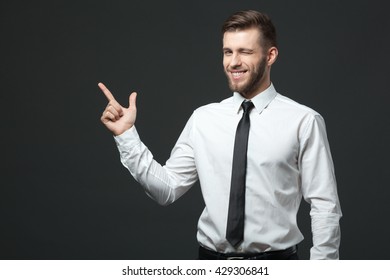 Your Logo Or Product Goes Here! Studio Shot Of Handsome Young Businessman Holding His Arm Up Presenting Copyspace.