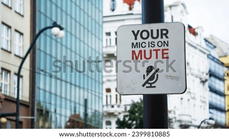 Your mic is on mute sign in a city business district