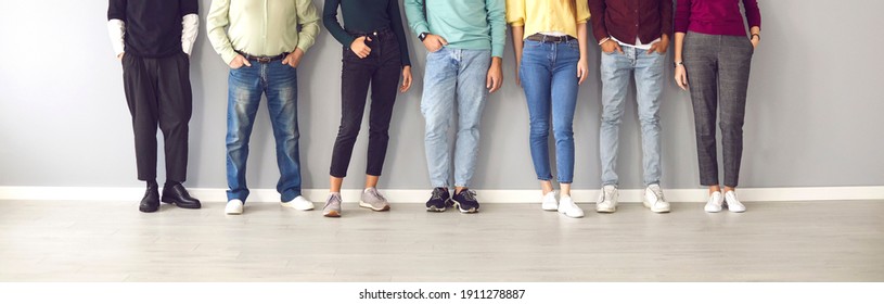 Your shoes says a lot about you. Cropped image of the legs of people in ordinary clothes and shoes standing in a row near the wall. Concept of diverse people in modern business. - Shutterstock ID 1911278887