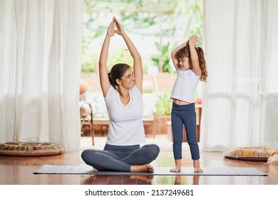 Youre Getting There My Child. Shot Of A Focused Young Mother And Daughter Doing A Yoga Pose Together With Their Arms Raised Above Their Heads.