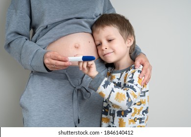 You're Going To Be A Big Brother! Pregnant Woman Show Her Little Son A Positive Pregnancy Test. Neutral Color, Copy Space, Horizontal