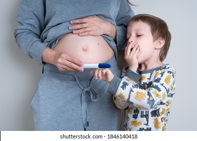 You're Going To Be A Big Brother! Pregnant Woman Show Her Little Son A Positive Pregnancy Test. Neutral Color, Copy Space, Horizontal