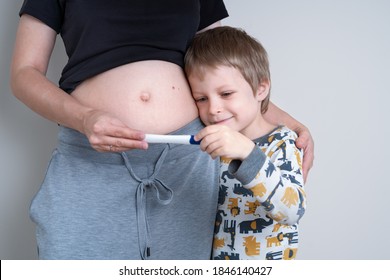 You're Going To Be A Big Brother! Pregnant Woman Show Her Little Son A Positive Pregnancy Test. Neutral Color, Copy Space, Horizontal