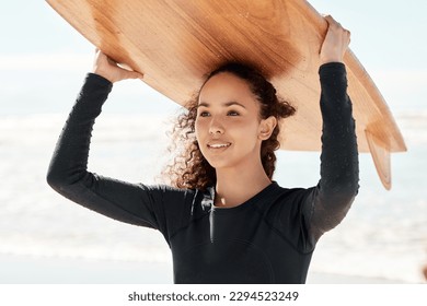 If youre having a bad day, catch a wave. Shot of an attractive young woman carrying a surfboard at the beach. - Powered by Shutterstock