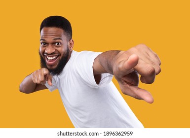 You're next. Funny african man pointing fingers at camera posing in studio on yellow background. I choose you concept, advertisement banner with cheerful black guy