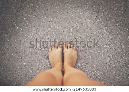 If youre wearing shoes, youre overdressed. High angle shot of a womans feet at the beach.