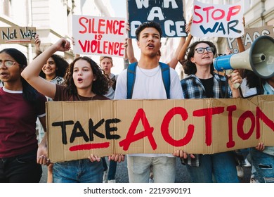 Youth activism for peace and human rights. Group of multicultural peace activists marching the streets with posters and banners. Diverse young people protesting against war and violence. - Powered by Shutterstock