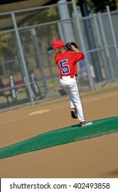 Youth Baseball Boy Pitching On Artificial Turf Mound During Game.
