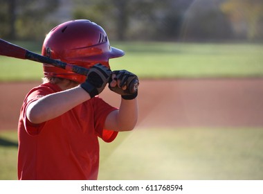 Youth Baseball Player With Bat And Batting Helmet Getting Ready To Hit