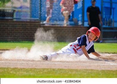 Youth Baseball Player Sliding In At Home.