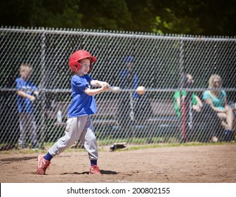 A youth baseball player takes a nice swing at the ball