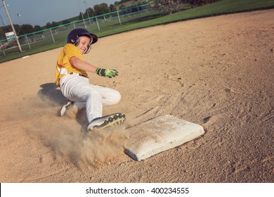 Youth Baseball playing sliding back to base. focus on base and foot