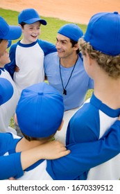 Youth Baseball Team In Huddle With Their Coach