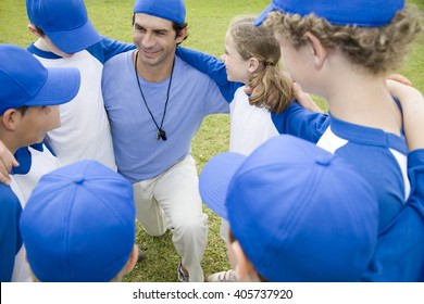 Youth Baseball Team In Huddle With Their Coach