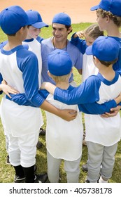 Youth Baseball Team In Huddle With Their Coach