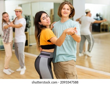 Youth Boys And Girls Learning To Dance Waltz During Group Class In Ballroom.